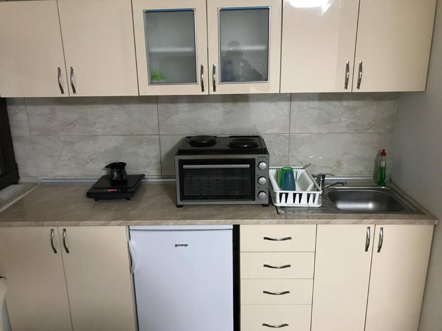 克拉列沃Dvokrevetni apartman sa kuhinjom的厨房柜台配有微波炉和水槽