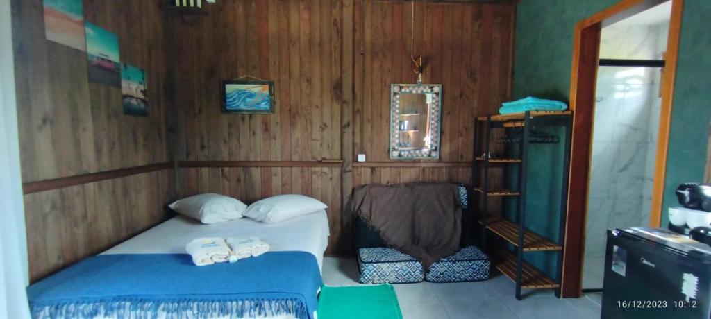 因比图巴Arandu Chalés的一间卧室设有一张床和木墙