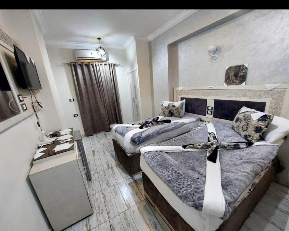 索哈杰Al Amir Palace Hotel的酒店客房设有两张床和电视。