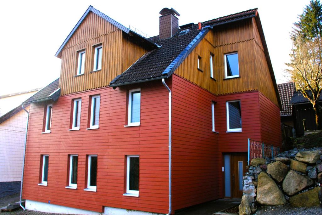 塔内Harzhaus Drei Hexen的黑色屋顶的红色房子