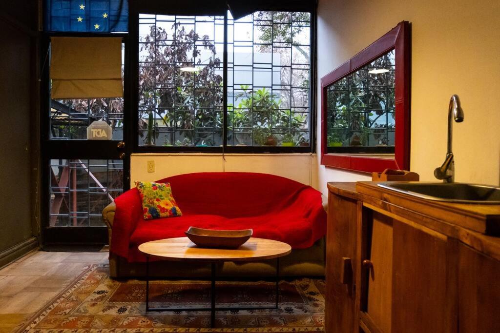 圣地亚哥Espacio Verde en Providencia的客厅配有红色的沙发和桌子