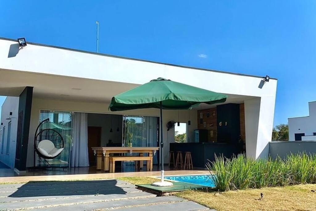 ItaíAconchegante casa na represa.的房子前面的绿伞
