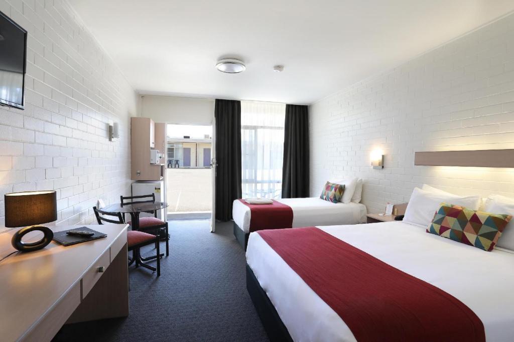 塔姆沃思Econo Lodge Gateway Tamworth的酒店客房配有两张床和一张书桌
