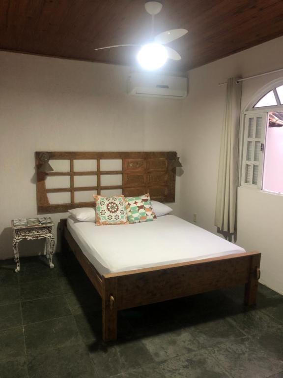 布希奥斯Casa de Família com Ar Condicionado, Garagem e Pet friendly的一间卧室配有一张带木制床头板的床