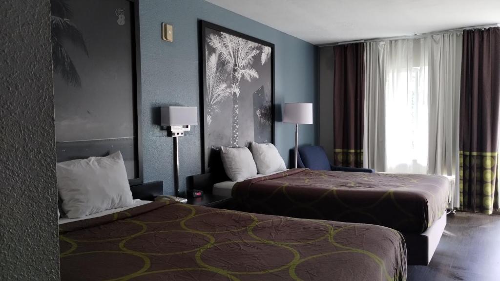 达尼亚滩Super 8 Motel by Wyndham near Fort Lauderdale Arpt的酒店客房设有两张床和窗户。