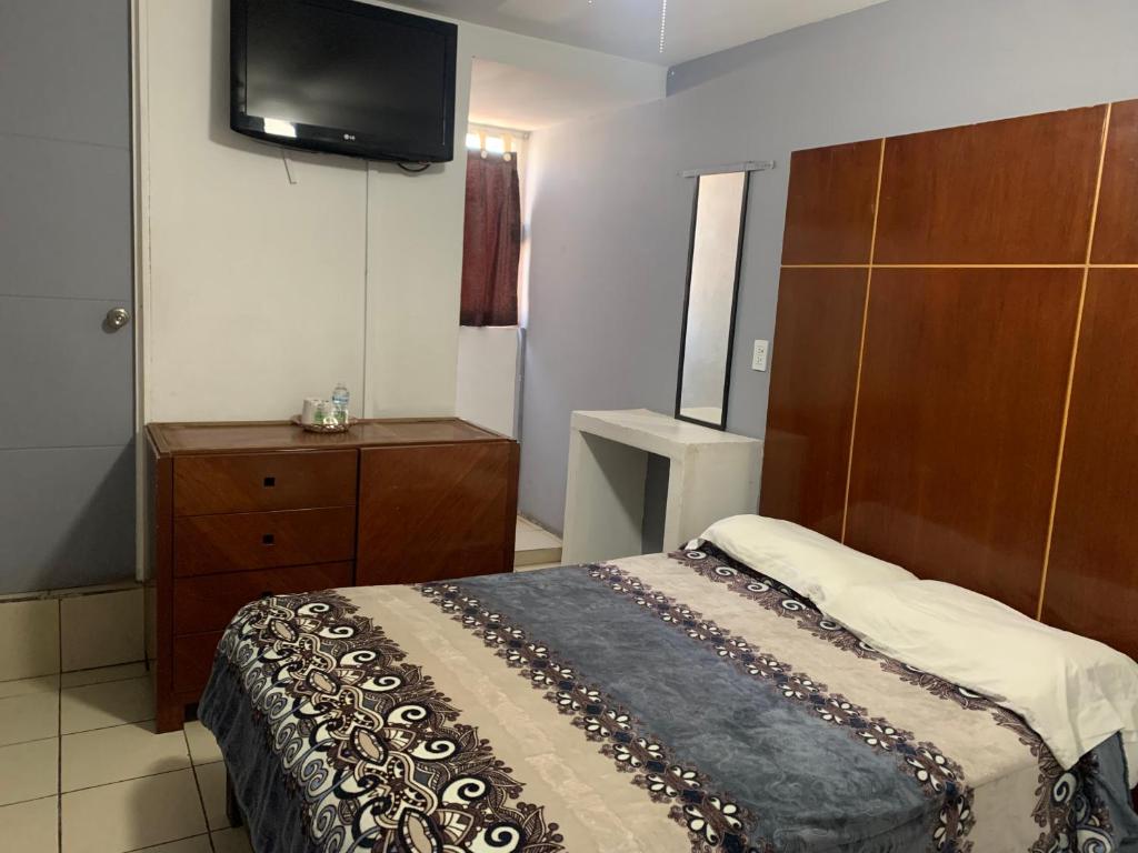 墨西哥城HOTEL PUERTO MEXICO 2的一间卧室配有一张床和一台平面电视