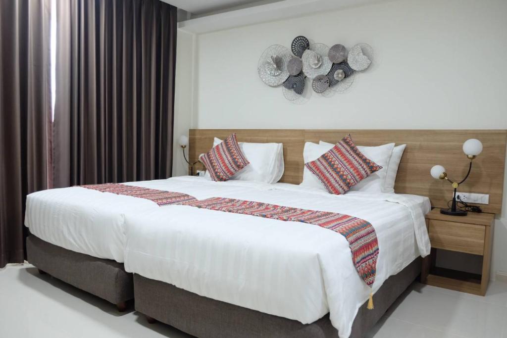 是拉差Christella Hotel Laemchabang的卧室配有带枕头的大型白色床