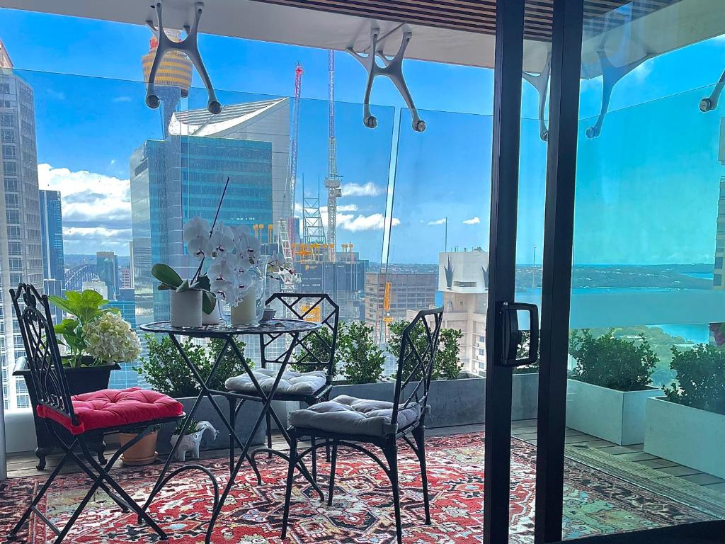 悉尼Sydney Cosmopolitan CBD Apartment的市景阳台配有桌椅。
