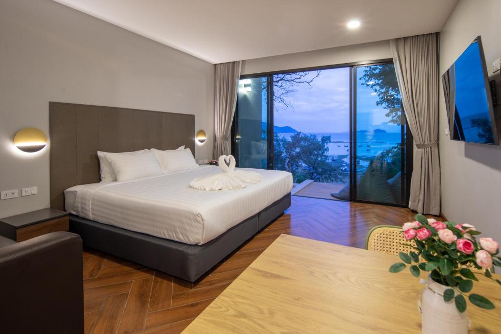 奈汉海滩Nature Vista Rawai的酒店客房设有一张床和一个大窗户