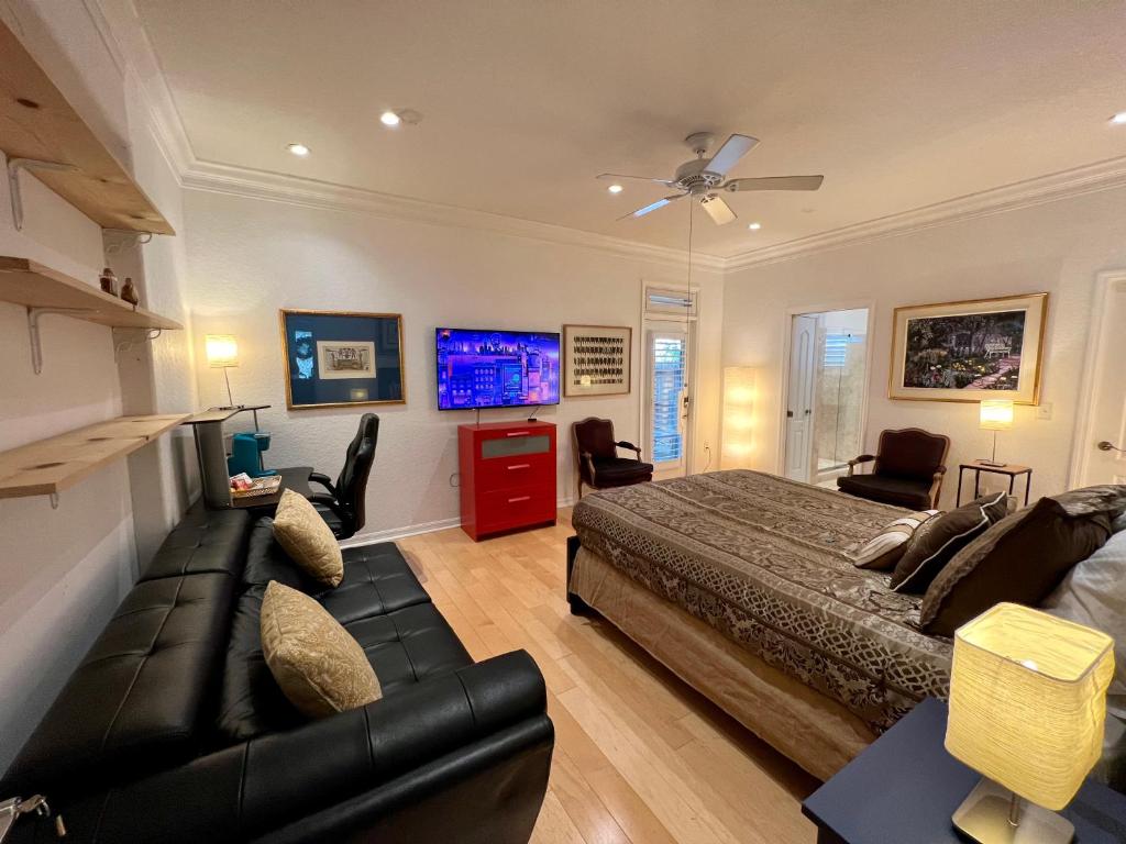 Lake AlfredThe Signature Orange Grove Suite的一间卧室配有一张床、一张沙发和一台电视。