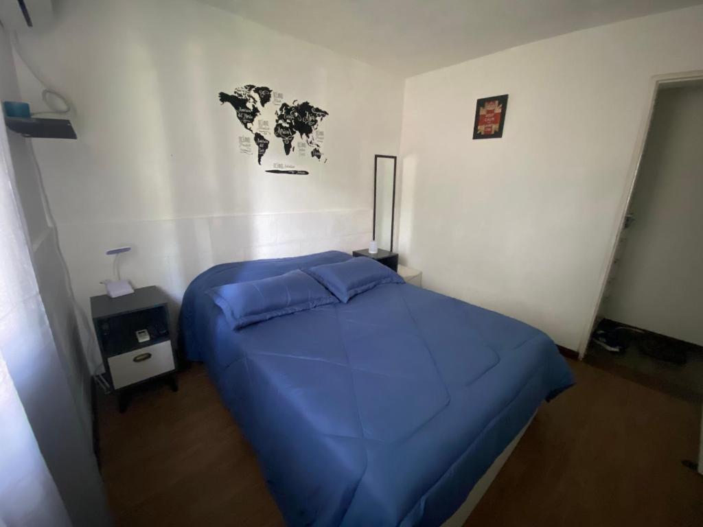 蒙得维的亚Lindo apto Mvd shopping puerto de buceo/pocitos的卧室配有一张蓝色的床,墙上挂有地图