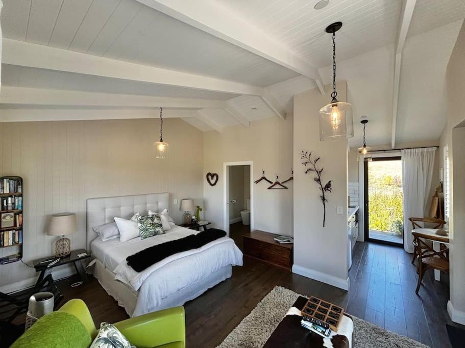 伦威克Luxury cottage with stunning vineyard views的一间卧室设有一张床和一间客厅。