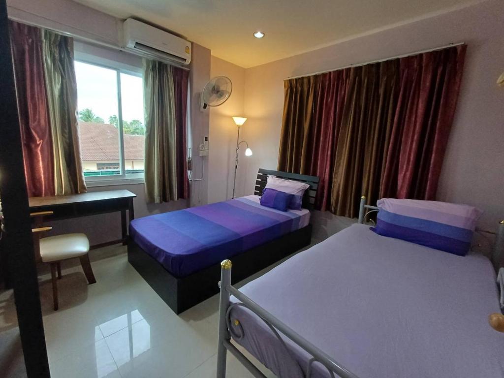 他朗168Hostel Airport@Phuket的一间卧室设有两张床、一张桌子和一个窗口。
