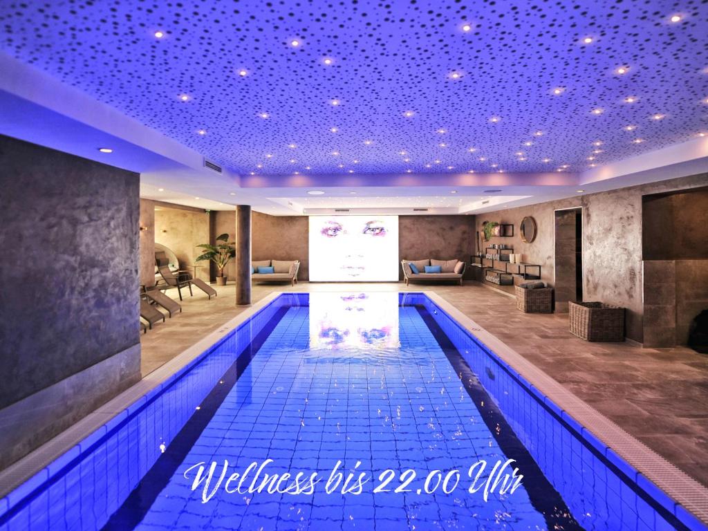 蒂罗尔-泽费尔德Die Seefelderin - Boutiquehotel St. Georg的一座带紫色天花板的建筑中的游泳池