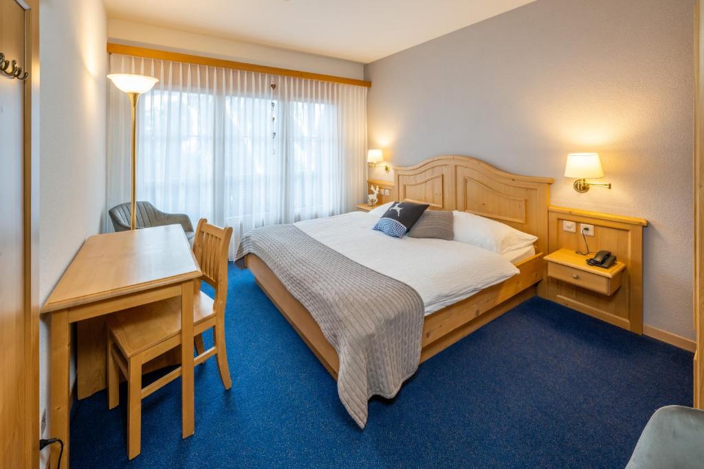 贝尔瓦尔德贝尔瓦尔德酒店的配有一张床、一张桌子和一张桌子的酒店客房