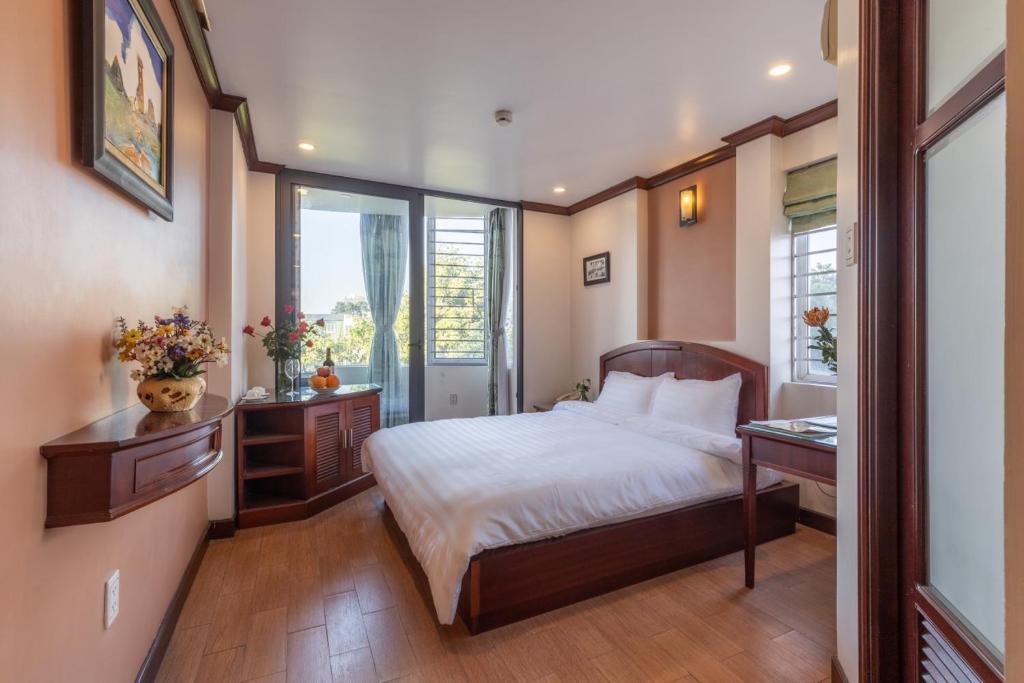 河内T - Apartment的一间卧室配有一张床、一张书桌和一个窗户。