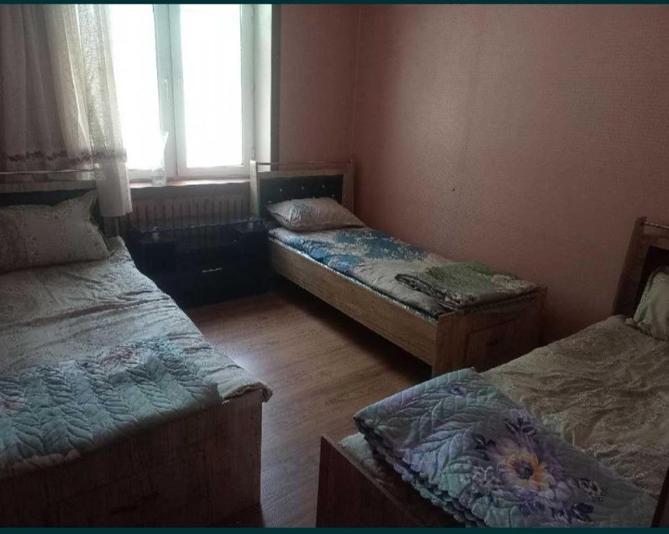 塔什干Гостевой дом Мусо的带三张床和窗户的客房