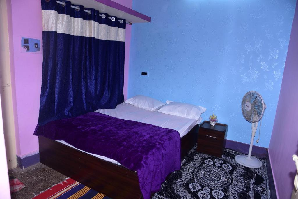 迈索尔S & H Stay Home的一间卧室配有紫色的床和蓝色的墙壁