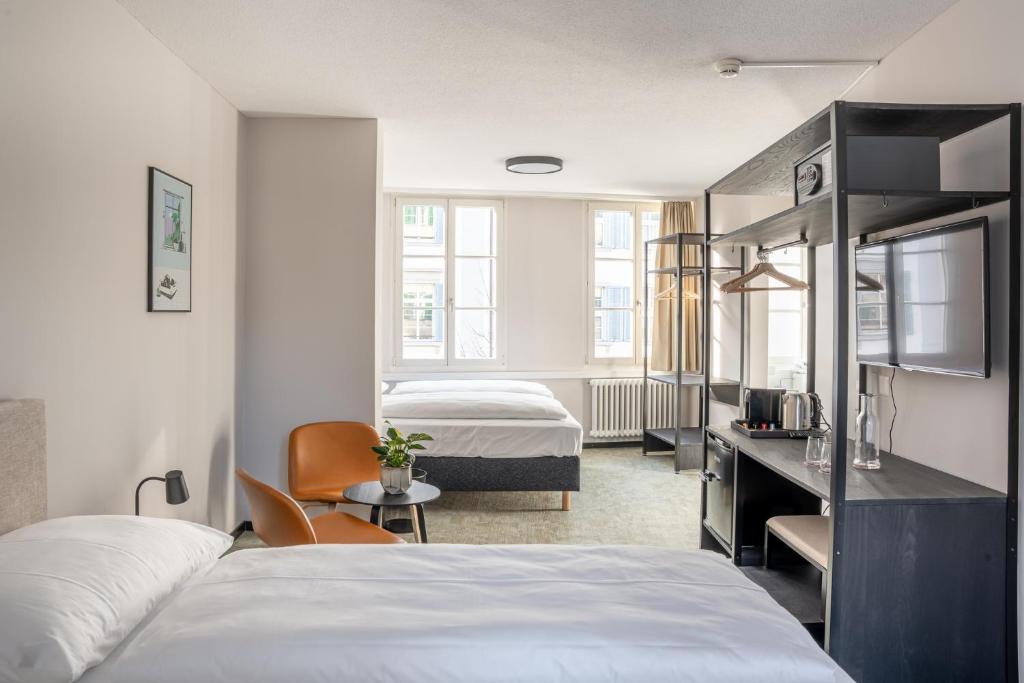 卢塞恩Hotel Goldener Stern - contactless check-in的酒店客房带两张床、一张书桌和一间卧室
