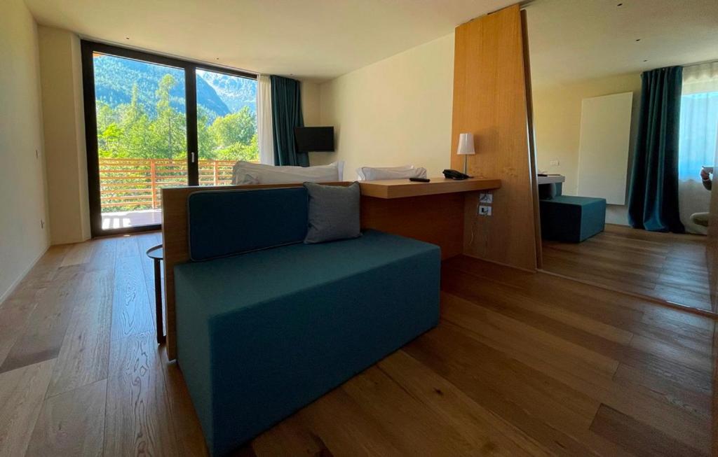 ChampdeprazMont Avic Resort & Wellness的客厅配有蓝色的沙发和书桌