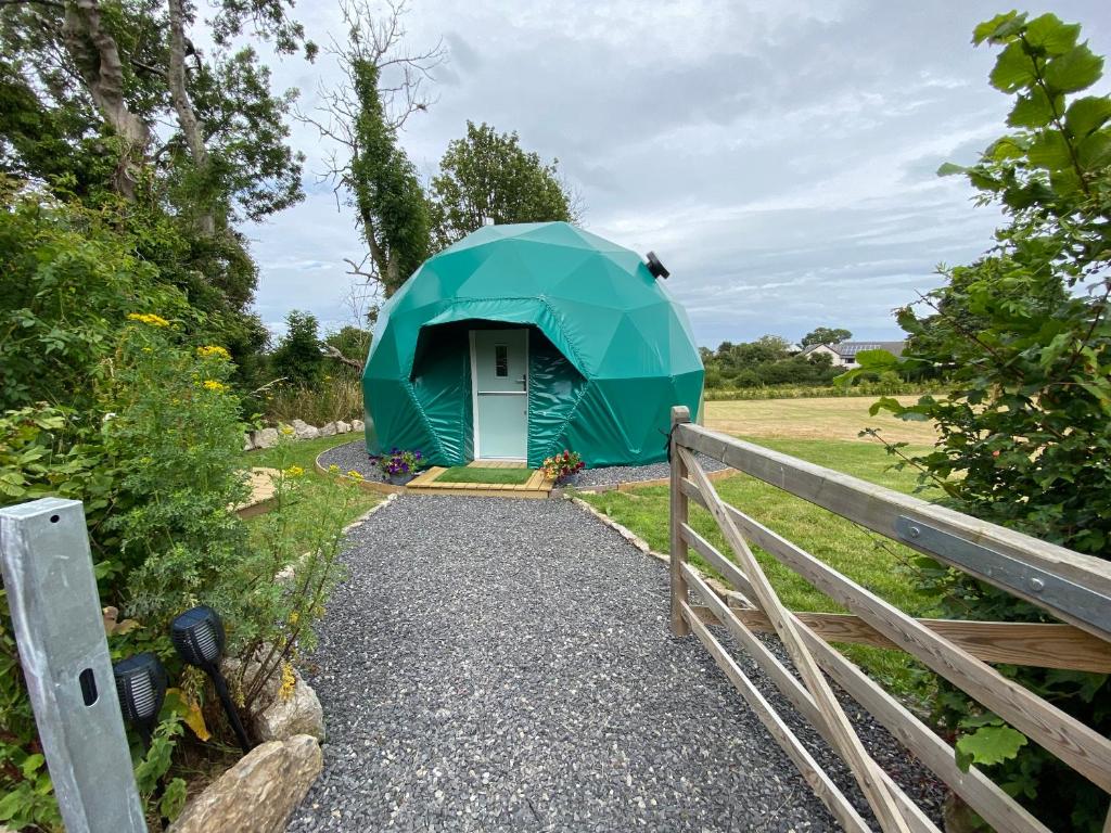本莱赫Benllech Glamping的绿帐篷,在有栅栏的田野里