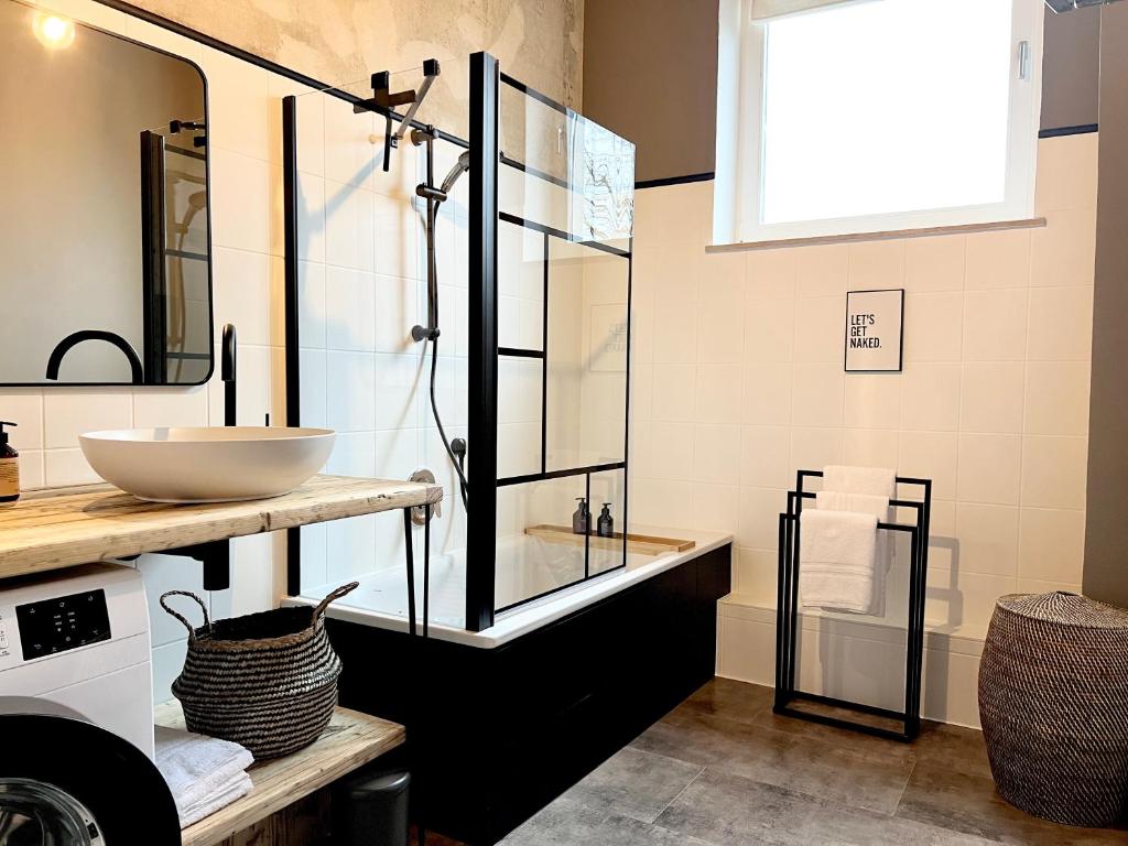 代特莫尔德MAKERS + ROOMS APARTMENTS的一间带水槽和玻璃淋浴的浴室