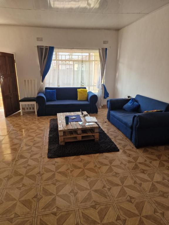 卢萨卡Salama House的客厅配有蓝色的沙发和咖啡桌