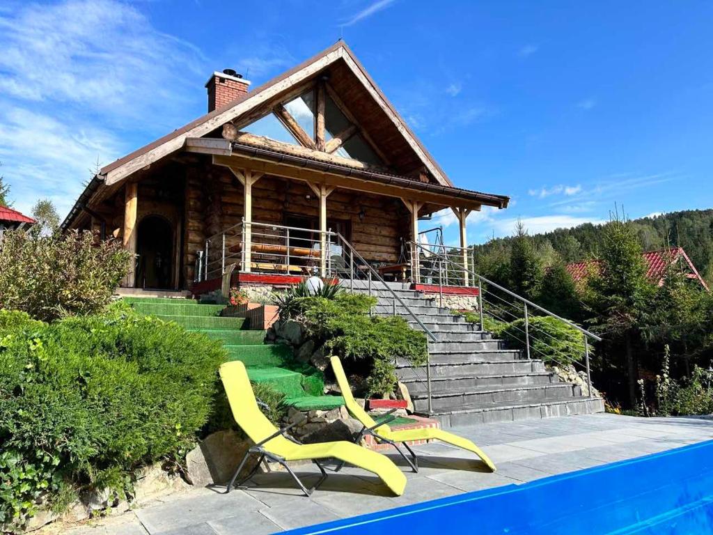 SólPod Smrekami的一座带游泳池和两张黄色椅子的房子
