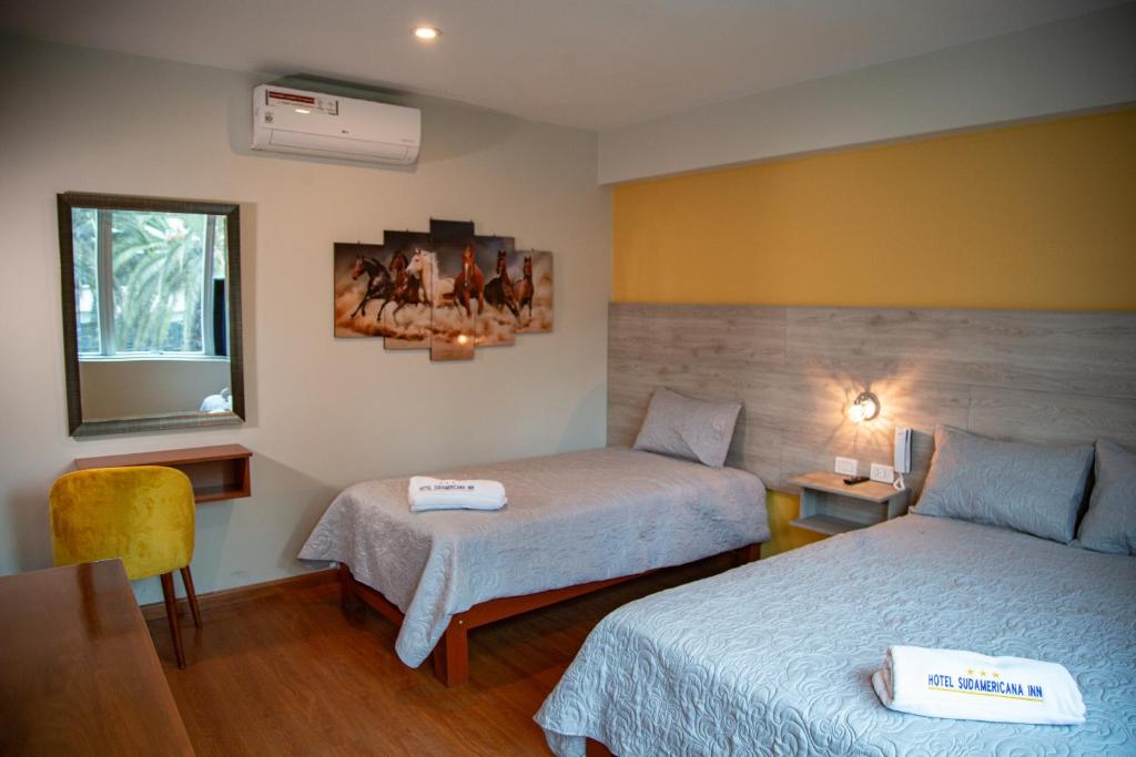 塔克纳HOTEL SUDAMERICANA INN的酒店客房设有两张床和窗户。