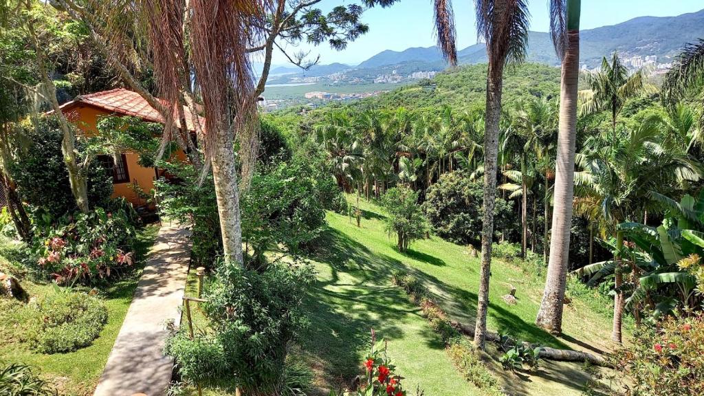 弗洛里亚诺波利斯Casa Vista Panorâmica的享有棕榈树花园和房子的景色