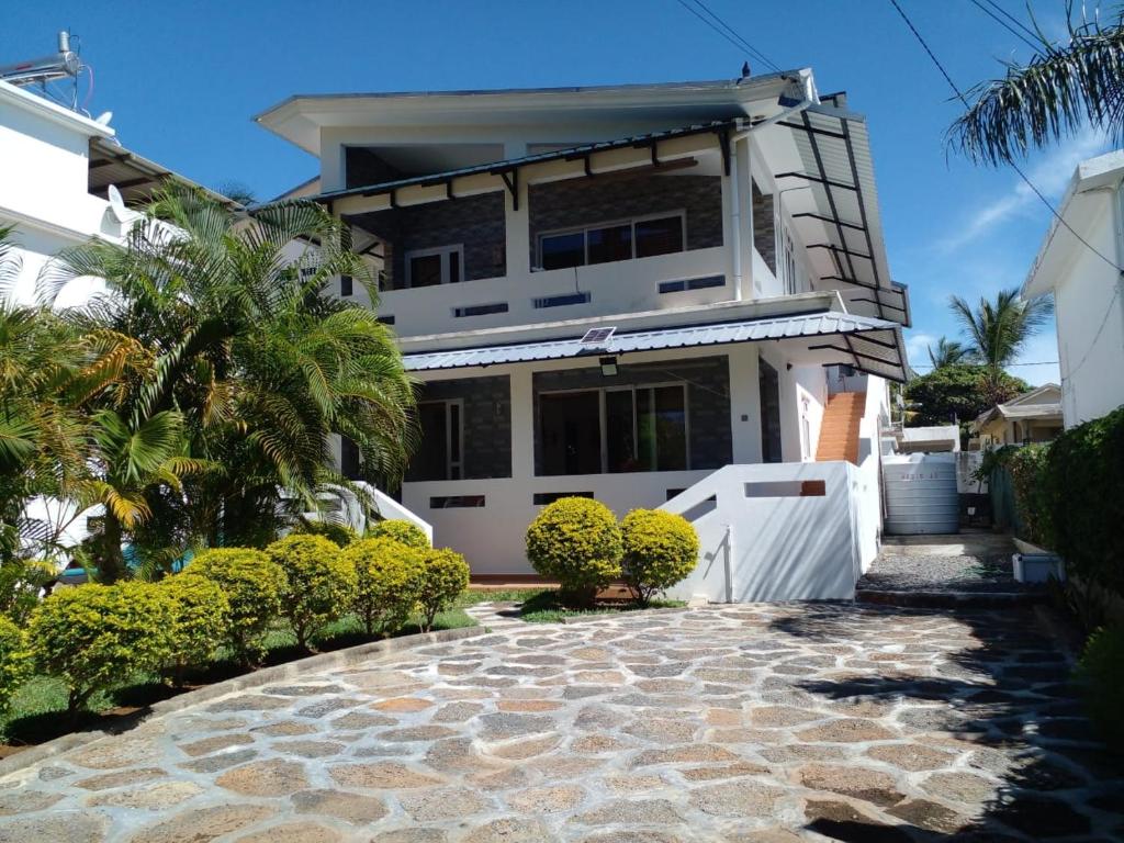 格兰高伯Real Mauritius Apartments的前面有石头走道的房子