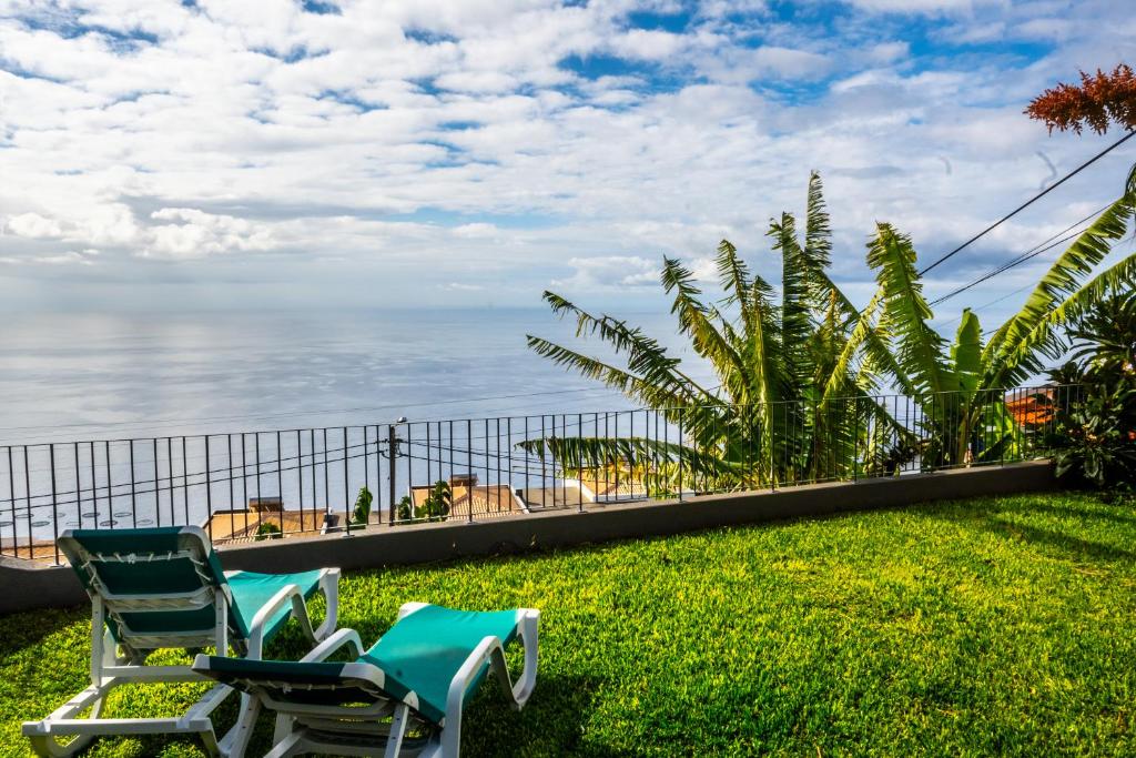 阿科达卡列塔Apartamento Domingos的两把椅子坐在靠近海洋的草地上