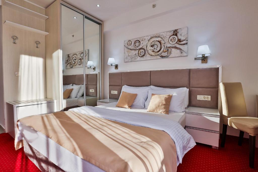 布德瓦Hotel La mer的一间卧室配有一张大床和一把椅子