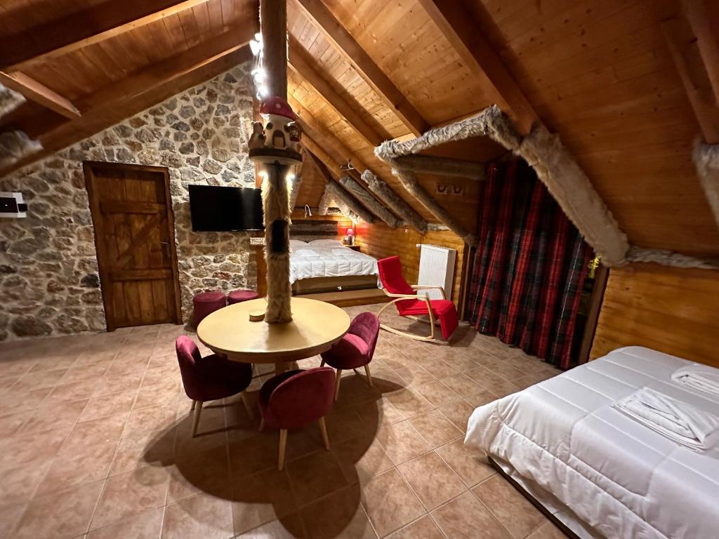 OítiΟ Σκίουρος Παραδοσιακοί Ξενώνες的卧室配有一张床和一张桌子及椅子