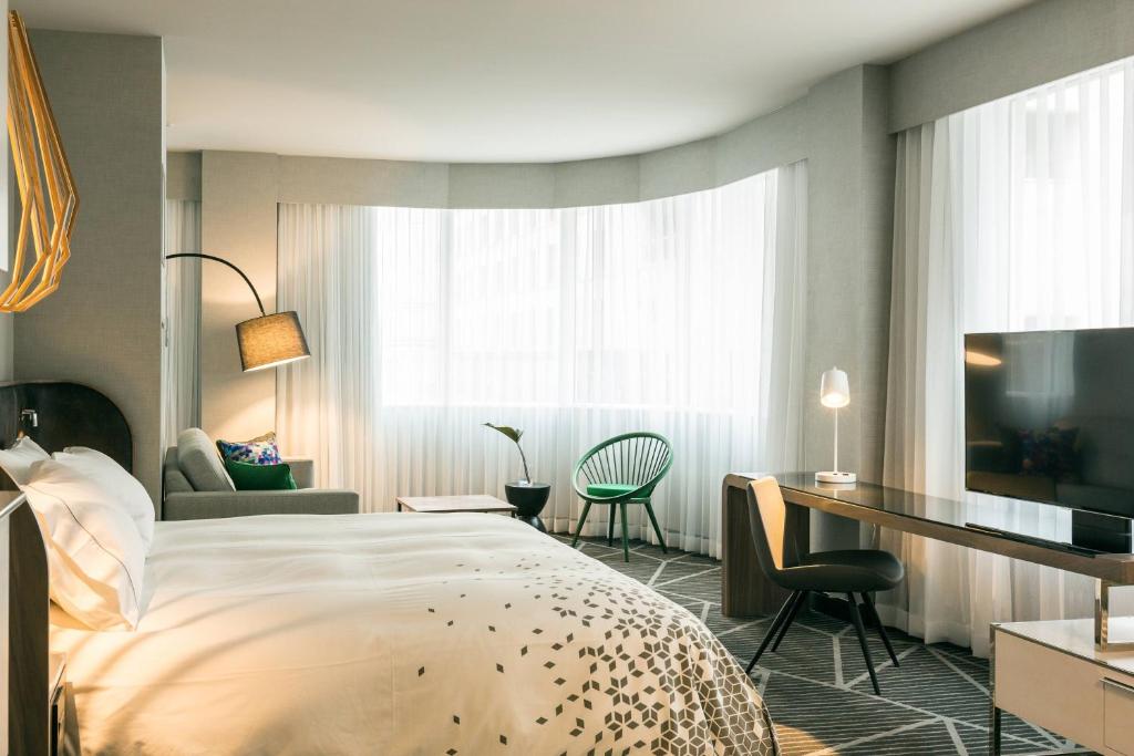 蒙特利尔蒙特利尔市中心万丽酒店的配有一张床和一张书桌的酒店客房