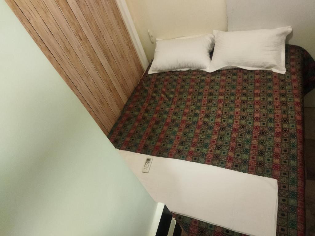孟买Near Airport AC Double Room at a Budget Inn的一张小床,上面有两个枕头
