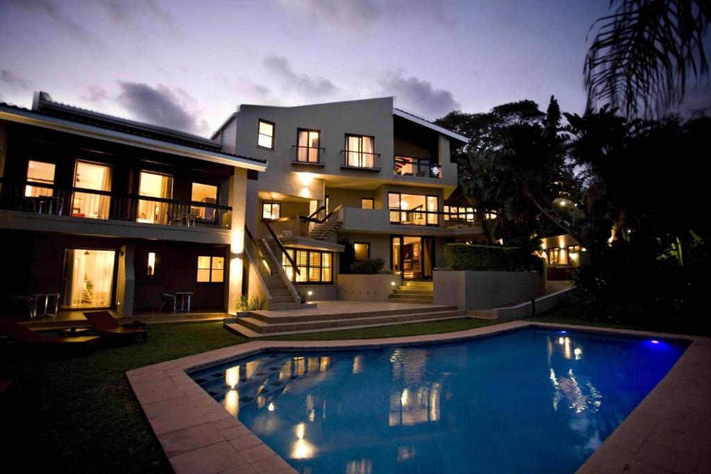 德班Teremok Lodge & Spa的一座大房子,前面设有一个游泳池