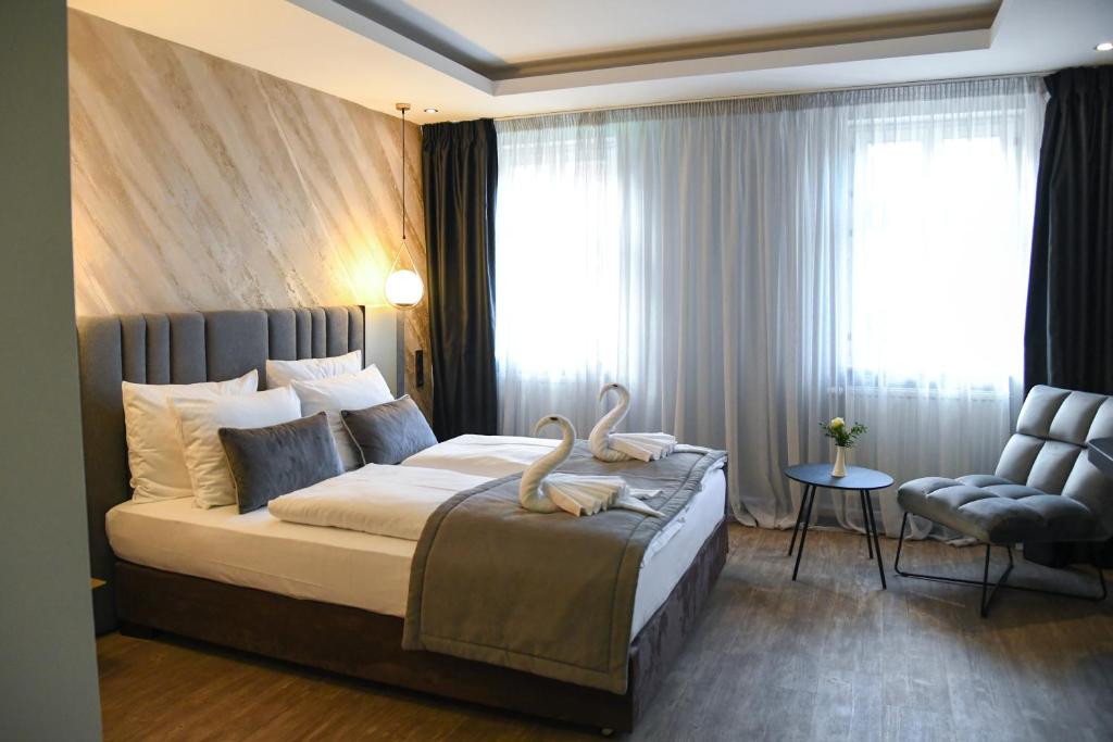 德利茨希祖姆维森罗斯酒店的一间卧室配有一张带两个天鹅的床
