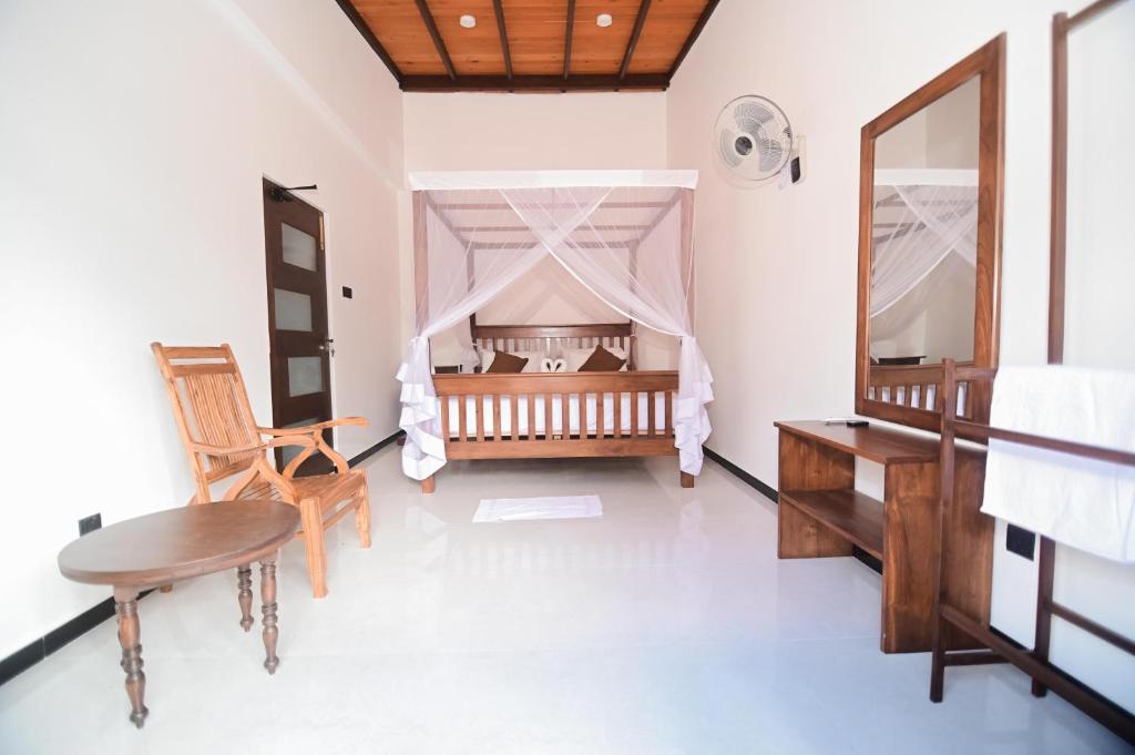 坦加拉Dream Villa - Tangalle的一间卧室配有婴儿床和桌椅