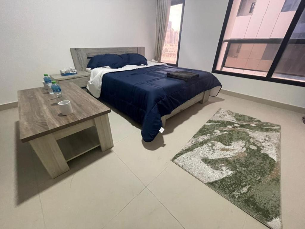 阿布扎比Heart of Abu Dhabi - Elite Community的一间卧室配有一张蓝色的床和一张桌子