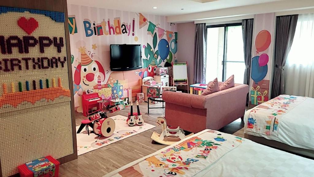 大寮乡义大天悦饭店的一间儿童房,带有生日快乐的标志和一间卧室