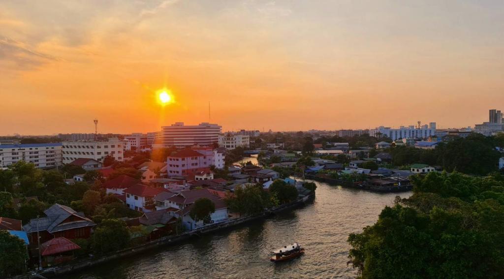 Bangkok NoiNORN Rimkhlong Bangkok นอนริมคลอง的河上城市的日落和建筑