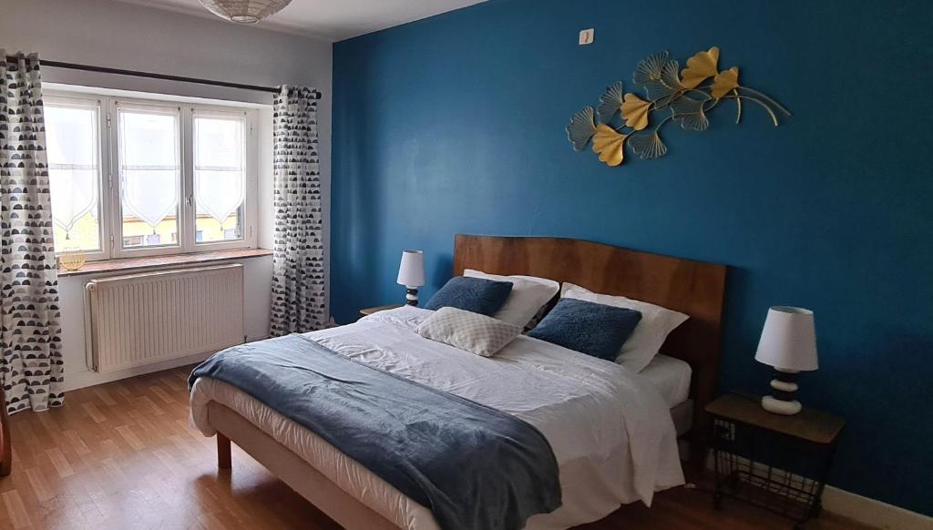 FoischesAncienne Fermette le Charlemont Givet Foisches的一间卧室拥有蓝色的墙壁,配有一张带蓝色枕头的床。