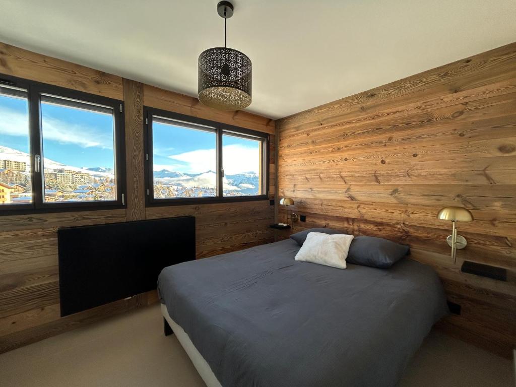 土绪尔Le Marlou的一间带木墙的卧室和一张带电视的床