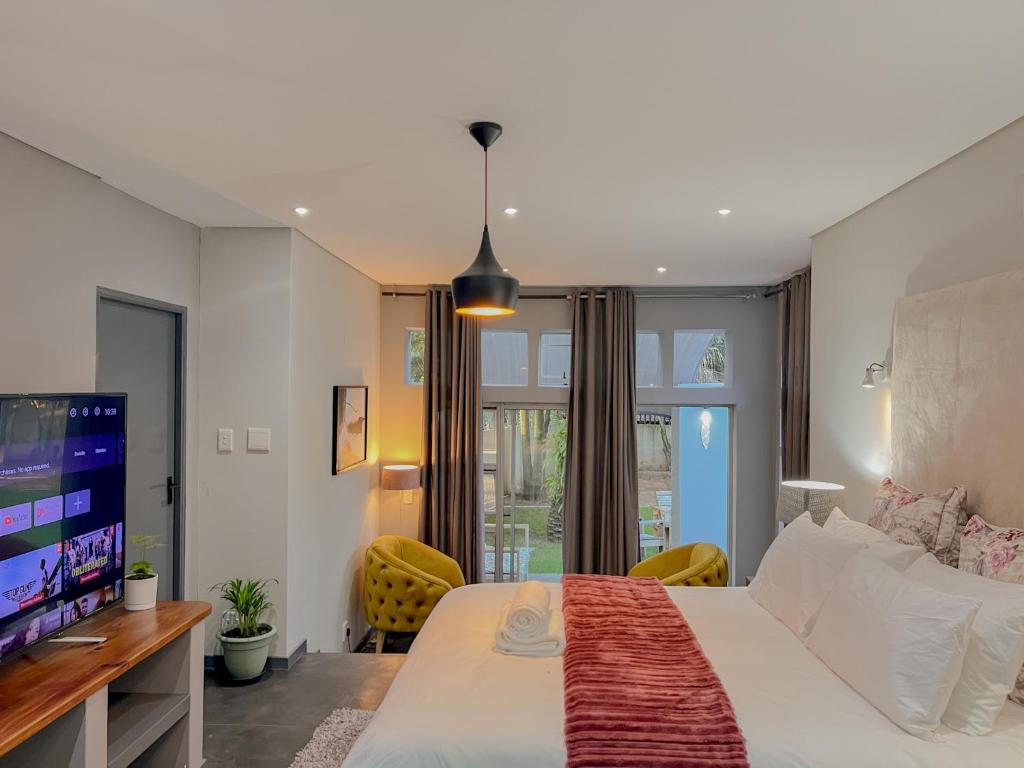 约翰内斯堡Amoris Guesthouse - Sandton的一间带大床和电视的卧室