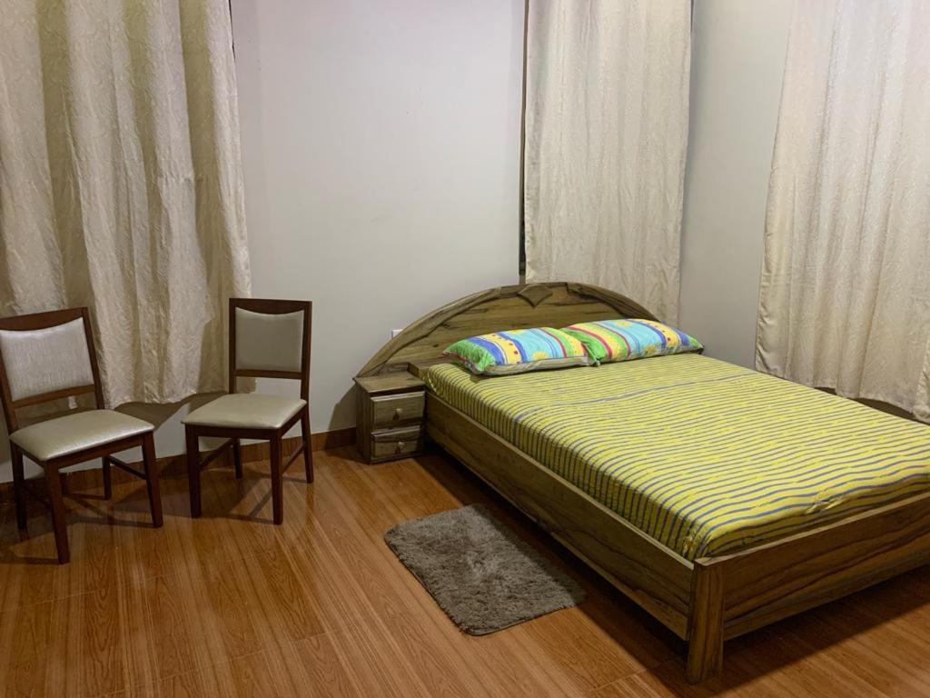 MiochoFamily & Friends Apartments的一间卧室配有一张床和两把椅子