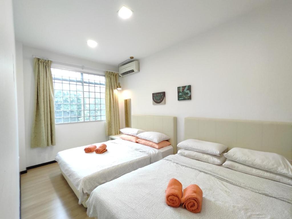 古晋Eden 8pax 3Rooms apartment near Kuching Airport的一间卧室配有两张带毛巾的床