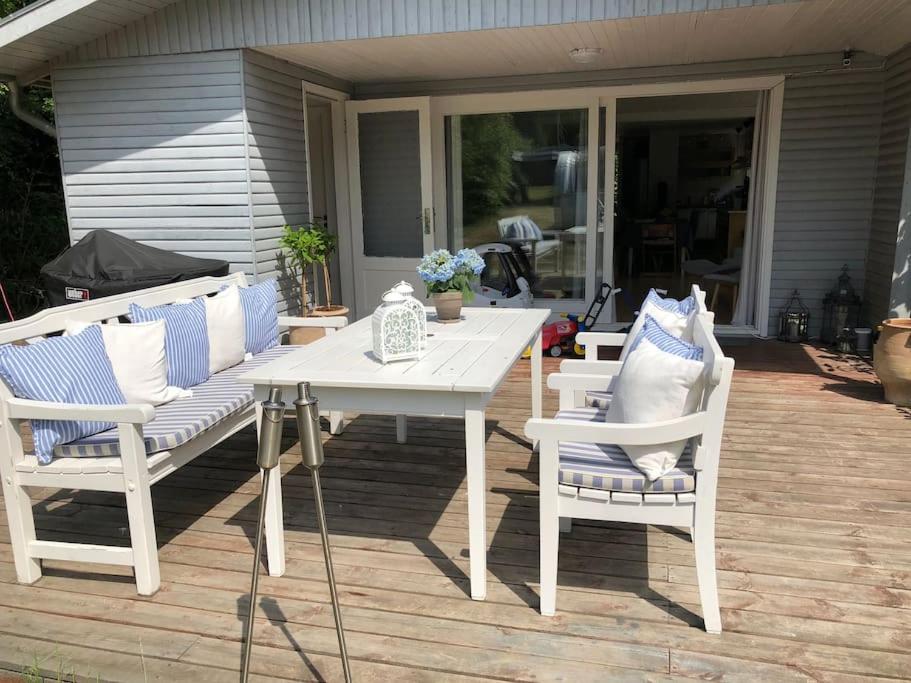 伦德Hyggeligt idyllisk hus的庭院里摆放着白色的桌椅