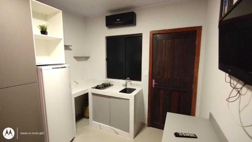 巴拉奈里奥-坎布里乌Quitinete compacta的一间带水槽和冰箱的小厨房