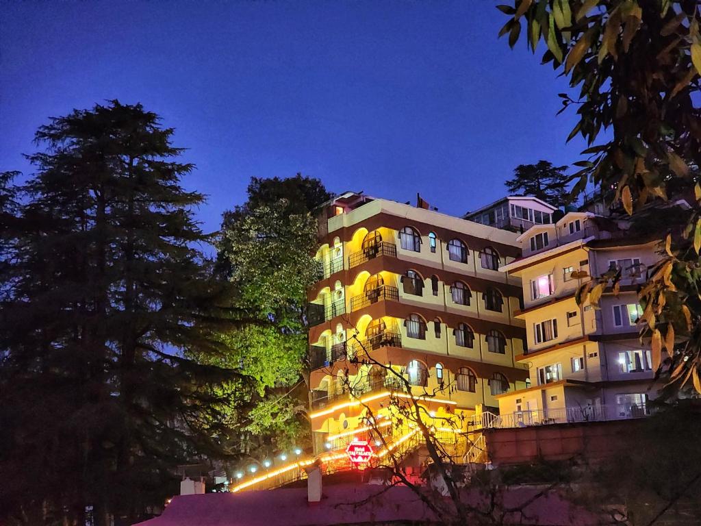 西姆拉Hotel Taj Palace near Mall Road的一座晚上有灯的建筑